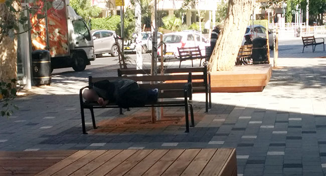 גבר שיכור ישן על אחד הספסלים במרכז המסחרי ברחוב הנביאים